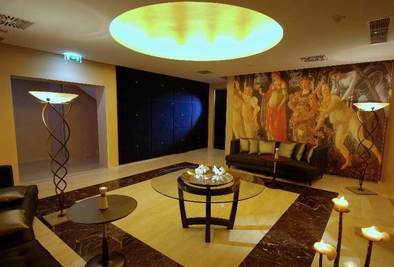 Grand Hotel Bernardin Portoroz Bagian luar foto The photo depicts an elegantly designed interior space, likely a lobby or lounge area. It features a modern aesthetic with a large, round ceiling light that emits a warm glow. The flooring is a combination of light and dark materials, creating a styl